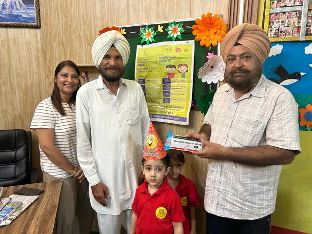 A child in a party hat with family members and a teacher